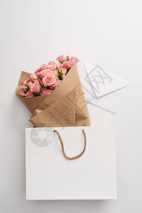 盛满美丽的粉红玫瑰花束和白信封图片