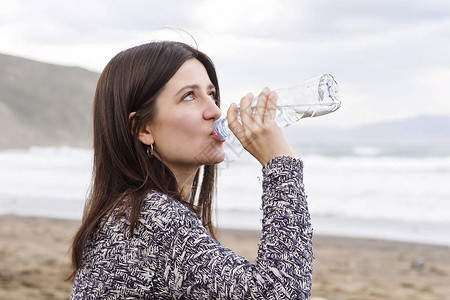 一个女孩从瓶子里喝淡水图片
