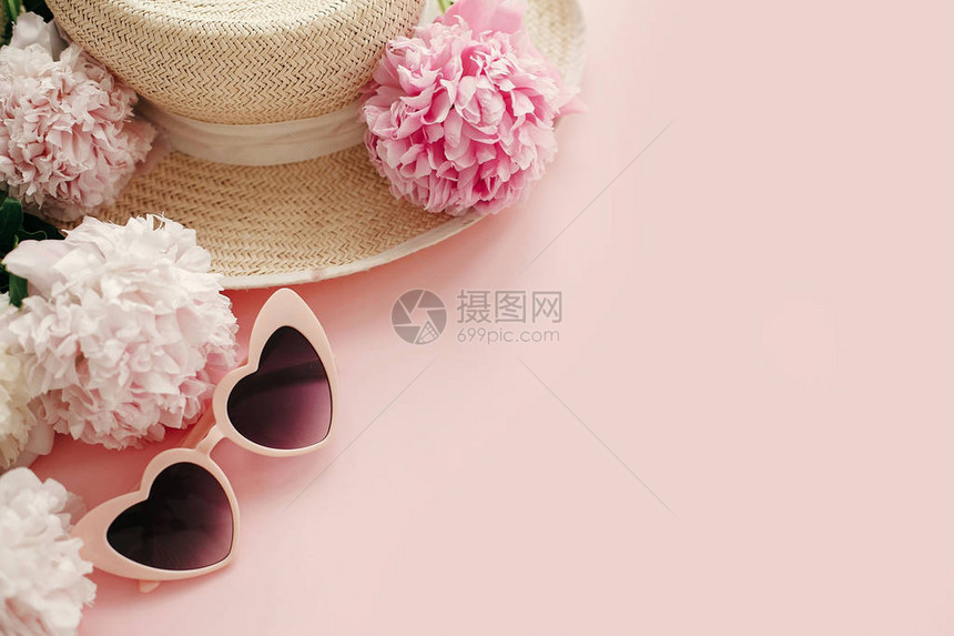 时尚的少女粉色复古太阳镜白色和粉色牡丹柔和粉色纸上的草帽图片