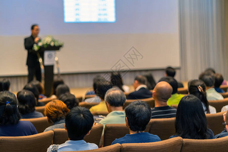 在会议厅的舞台上用讲台聆听演讲者的观众后侧商图片