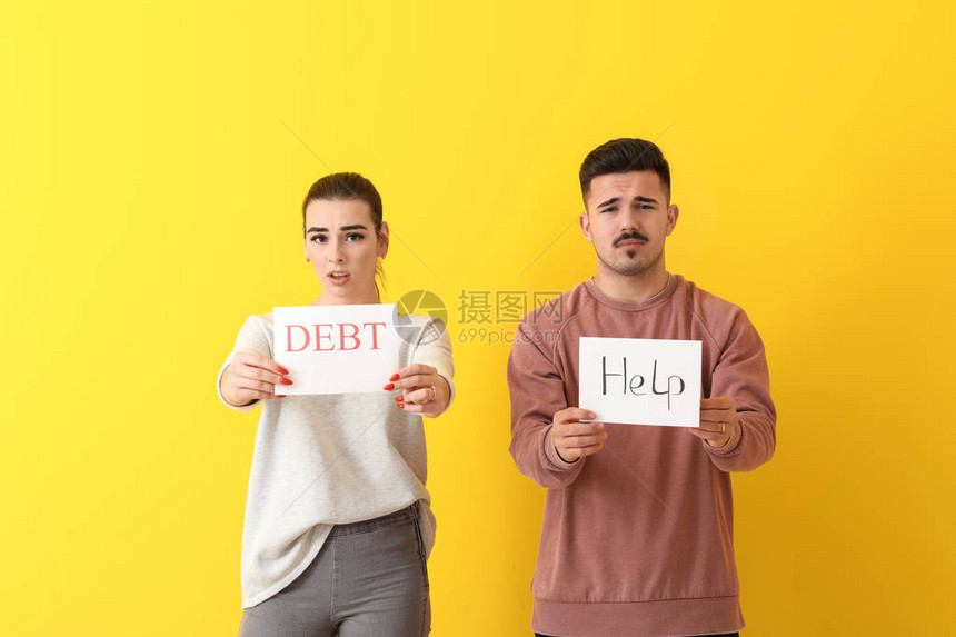 担心年轻夫妇持有文本DEBT和彩色背图片