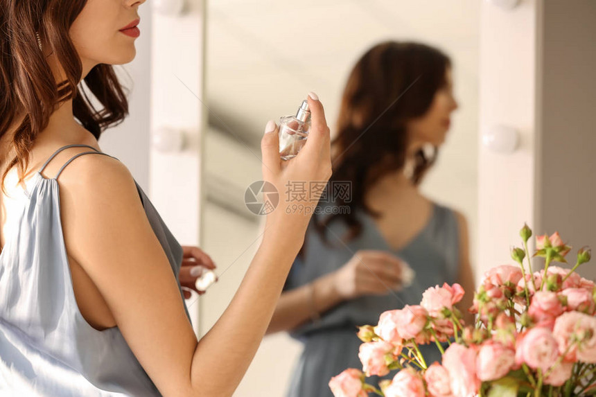 美丽的年轻女子在镜子旁图片