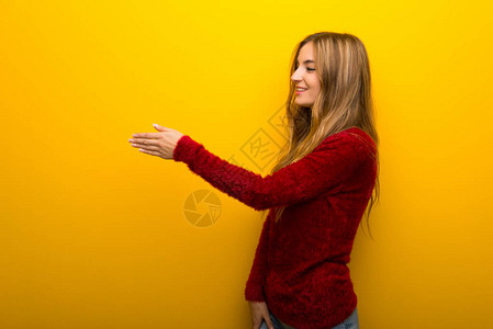 年青女孩在黄色的生气背景下卖了图片