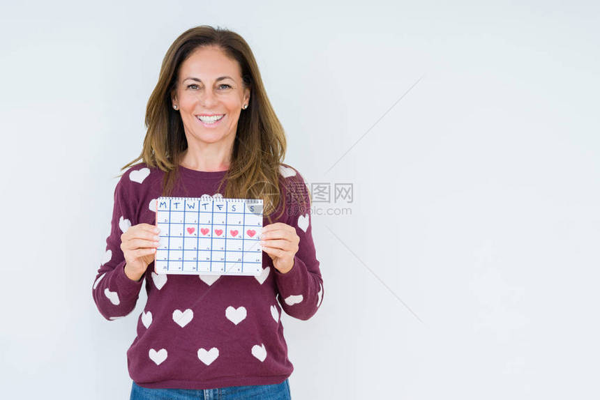 中年妇女在孤立的背景下拿着月经日历图片