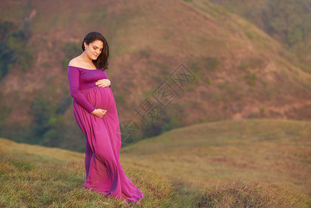 孕妇在自然背景下拥抱腹部图片