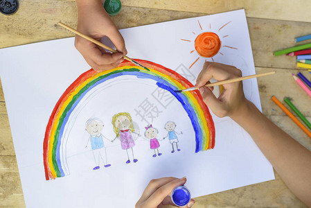 两个孩子的手用刷子和颜料画了一图片