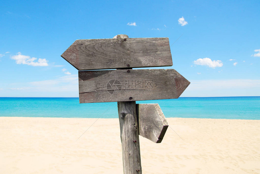 夏季旅游目的地选择在沙滩和海上用木箭指示路标图片