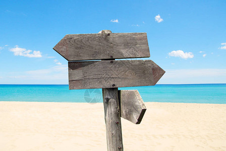夏季旅游目的地选择在沙滩和海上用木箭指示路标图片