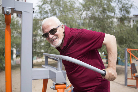 有吸引力的老人在露天城市训练运动器材每个人的健康生活方式和运动训练的可及概念公共场所背景图片