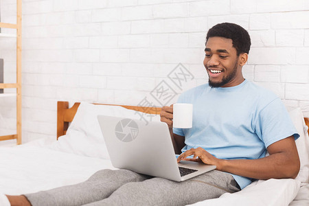 非裔美国人的千年男子在笔记本电脑上看新闻图片