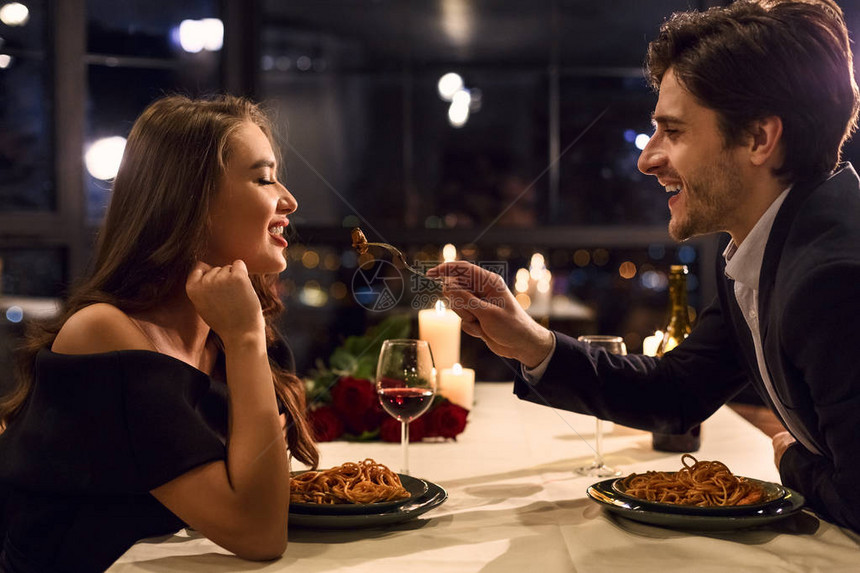 浪漫情侣在餐厅吃晚饭互相喂食图片