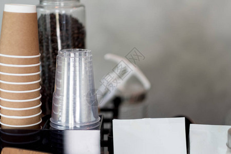 透明塑料杯和棕色纸板杯倒转的一行作为背景咖啡菜单概念图片