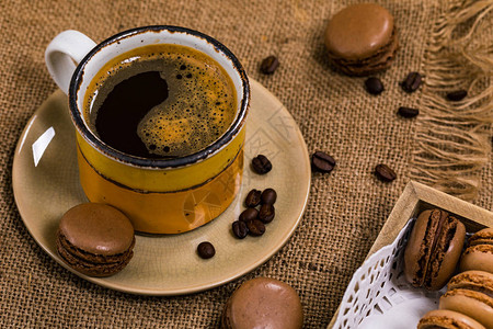 深巧克力麦卡伦和咖啡豆在木质桌上图片