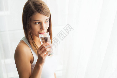 健康的生活方式年轻女子从玻璃中饮用清爽纯净水的特写肖像卫生保健饮料水健康美背景图片