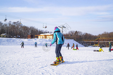 一个穿着特别的彩色西装的女孩冬季游乐和运动学会了在阳光明媚图片