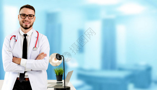 医院办公室的英俊医生站着看照相机医疗保健和医生工作人员服务等图片
