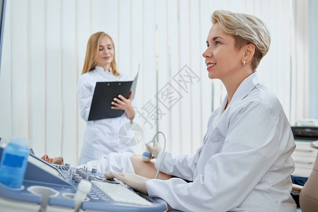 医生办公室中与病人打交道的妇女的侧面观点图片