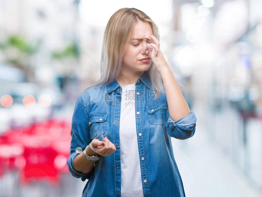 身处孤立背景的金发年轻女子闻到一些臭味恶心无法忍受的气味图片