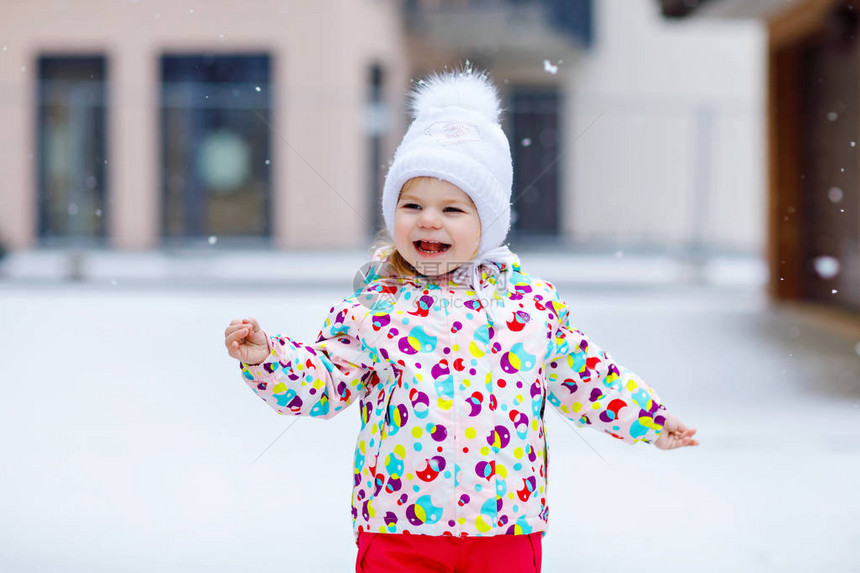 可爱的蹒跚学步的小女孩在冬天户外散步可爱的蹒跚学步的孩子吃甜棒糖孩子在寒冷的雪天玩得开心穿着温暖的婴儿五颜六色的衣服和图片