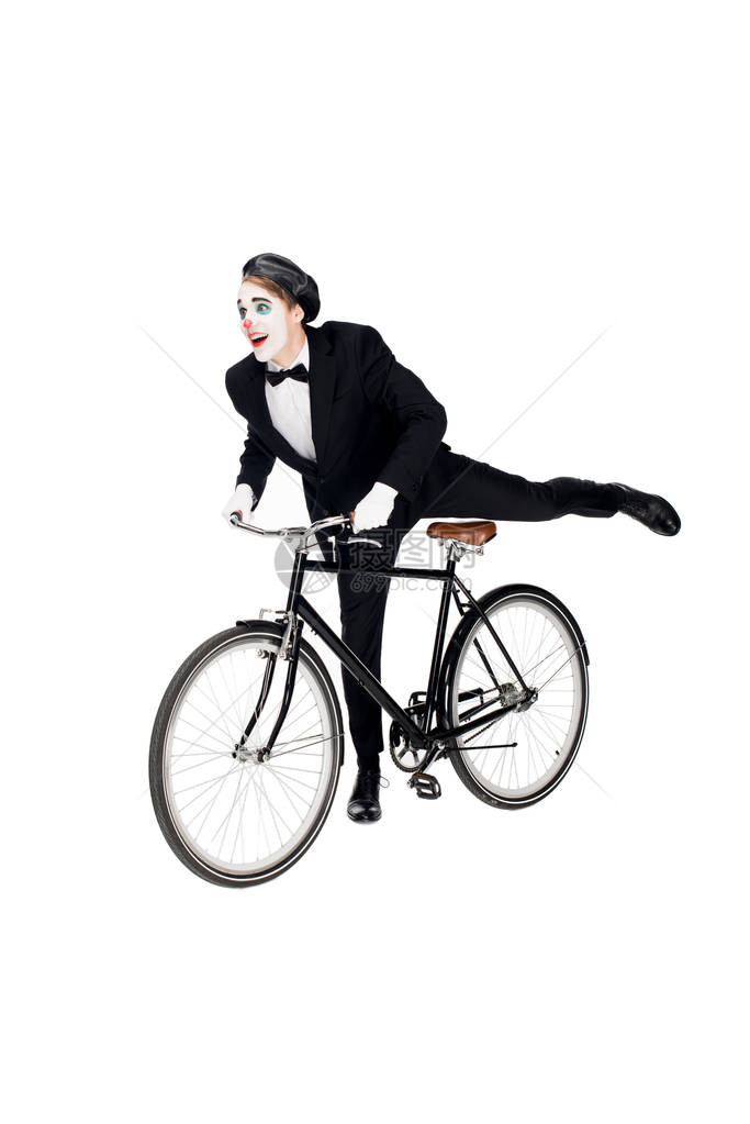 穿着西装骑自行车的快乐小丑与白色隔离图片