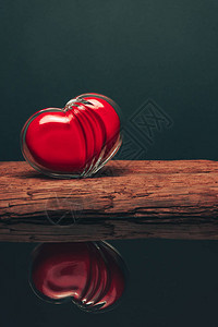 红色的玻璃心放在旧木制桌子上美图片