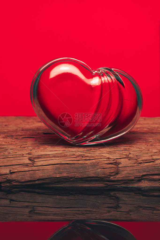 红色的玻璃心放在旧木制桌子上美图片