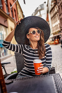 格开朗的时尚女人戴着太阳镜和时尚的帽子图片