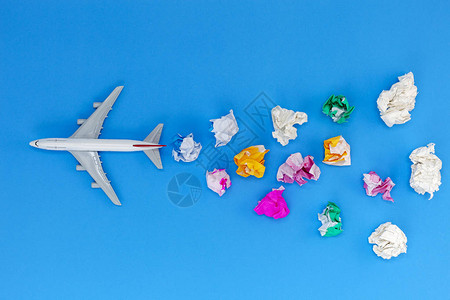 飞机模型与各种纸球在蓝色背景与复制空间旅行和旅图片