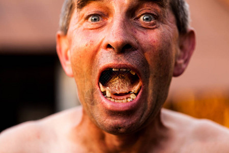 关闭显示丑陋假牙的一位老人蛀牙在张开的嘴里堆积个人卫生和维护不佳不健图片