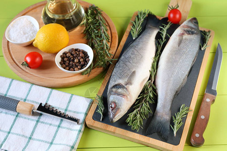 在烹饪前鱼肉在切削板和原料图片