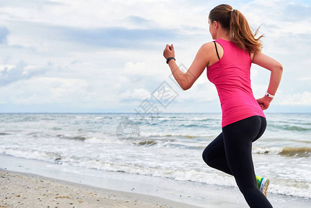 运动女子在海滩上奔跑图片