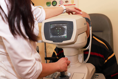 年轻女子接待医生眼科医生检查眼睛视力的质量近视远视的概图片