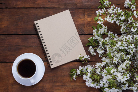 一杯黑咖啡笔记本樱桃喷雾花朵在黑图片