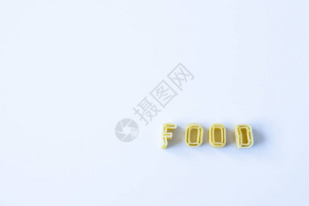 食物一词在自然光的白色表面上由真正的意大利面字母组成背景与左图片