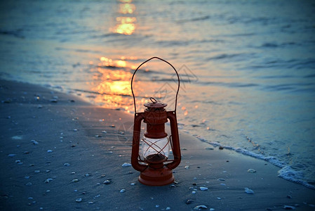日出时海上的老式油灯图片