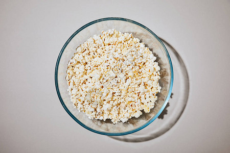白色背景碗中美味爆米花的顶部视图背景图片