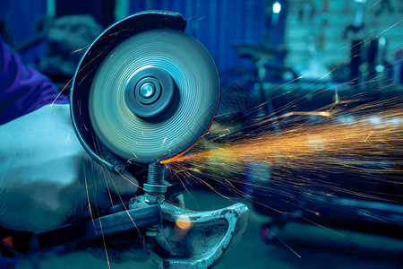 一名强壮的焊工在车间焊接一台金属汽车零件焊接机图片