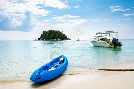 Kayak蓝船和快艇锚定活动和白沙水图片
