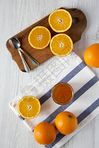白色木质背景上的自制橙色果酱图片