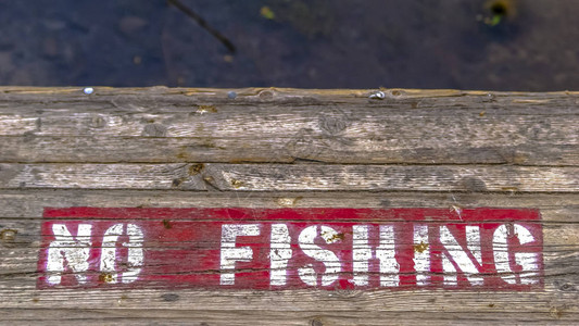 带有彩绘禁止钓鱼标志的木制平台图片