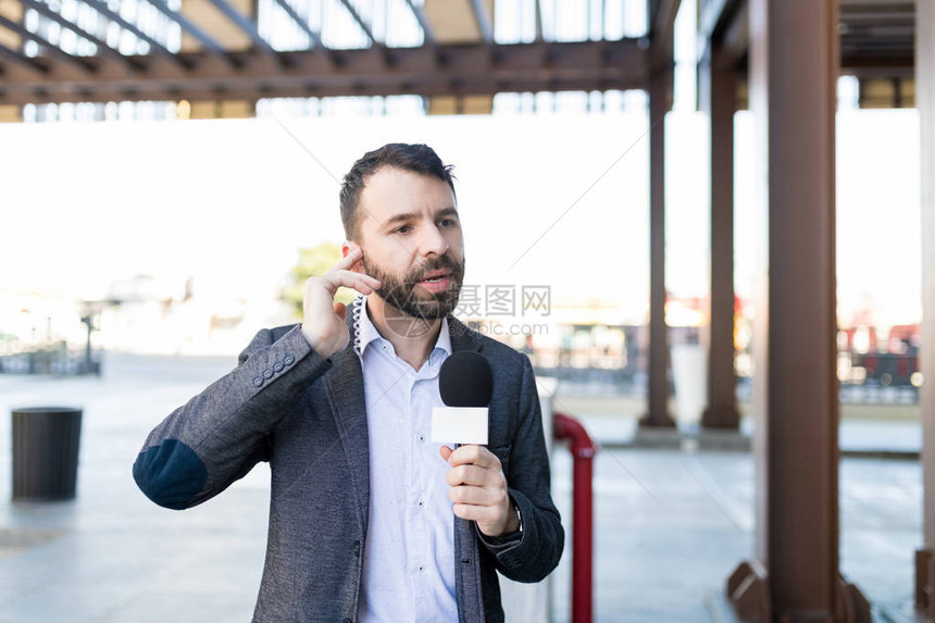 一名西班牙裔男新闻播报员在广播中用麦克风对着他图片