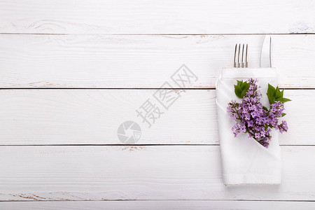 餐桌白色木制桌上有古老的餐具和花朵图片