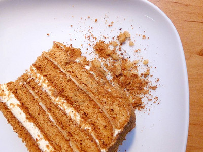 白色盘子上有碎屑的传统蜂蜜蛋糕切图片