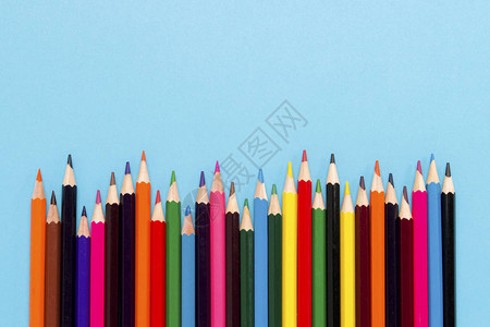 彩色铅笔以蓝色背景的波形式呈现出来平面图片