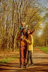 母亲和父亲背着小儿子玩纸飞机的灵感家庭是灵感的源泉背景图片