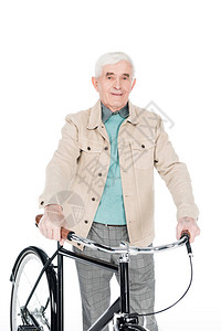 怀着微笑的退休男子他骑着自行车在白图片