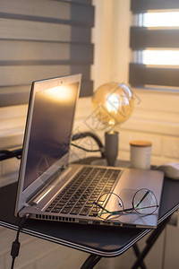 配备黄灯和黑桌上笔记本电脑的自由职业自由职业者现代图片