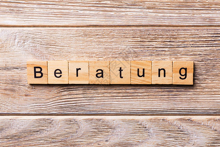 写在木块上的Beratung字在木桌上为您设计概念的Berat图片
