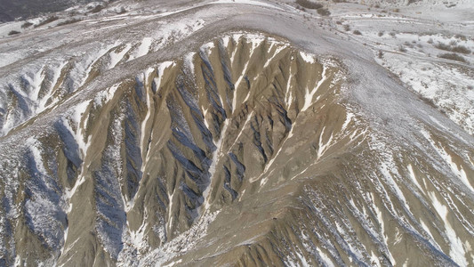 白雪覆盖的山脉的多彩景观拍摄冬季丘陵景观的顶视图图片