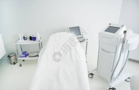 激光理发机和舒适的日间床铺上面盖有白床图片